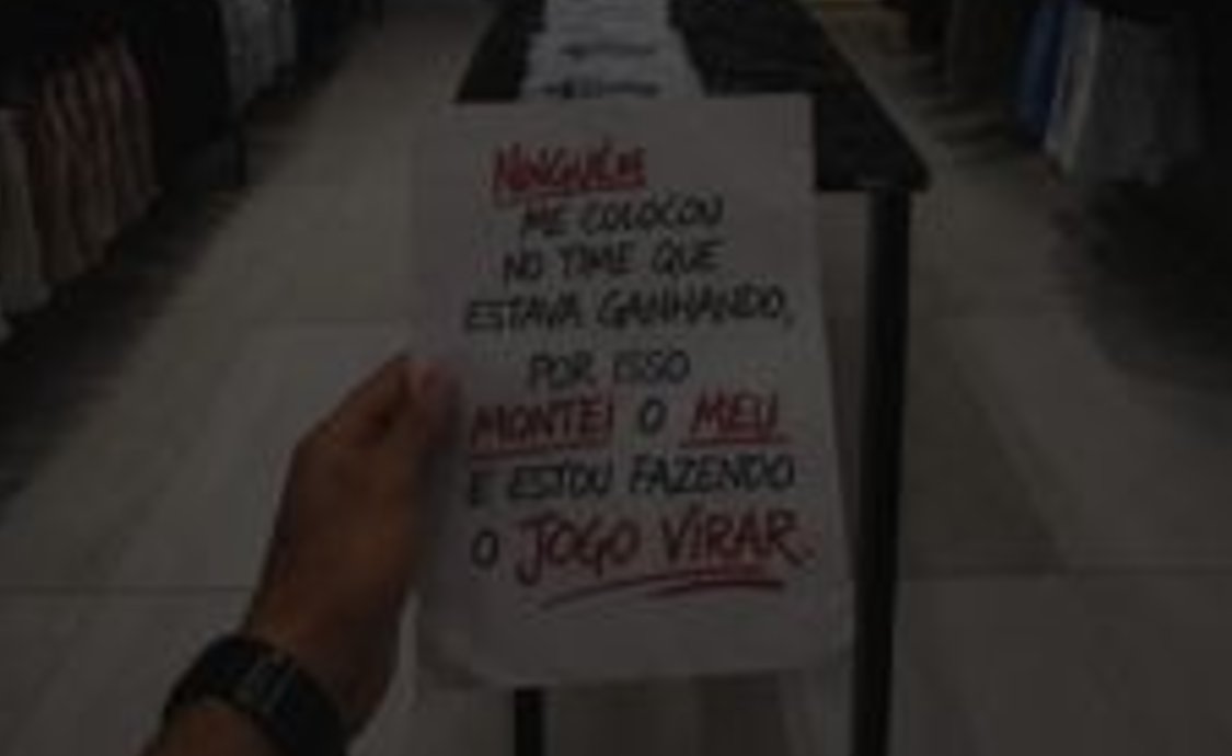 Cartaz escrito à mão exposto dentro da loja MS GRIFES